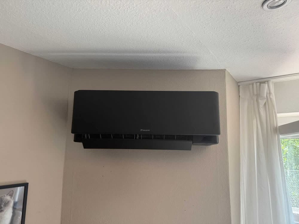 Schwarzes Daikin Klimagerät an einer Wand.